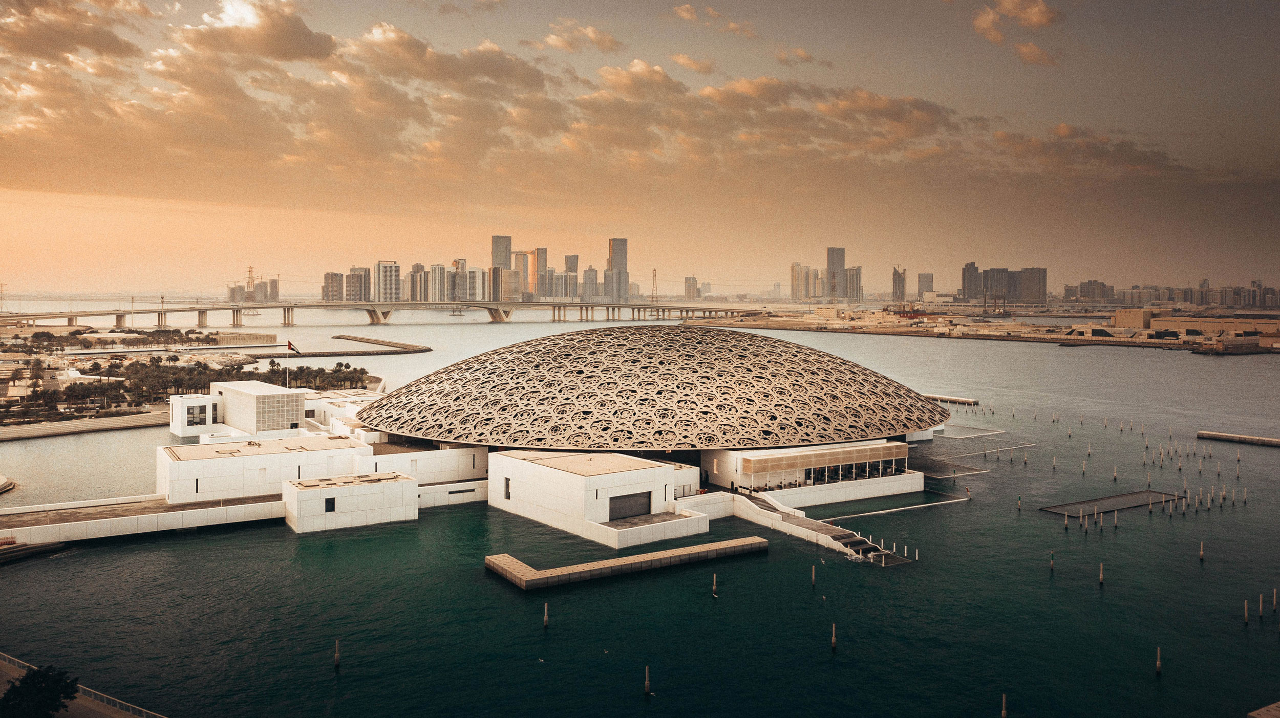 Louvre Abu Dhabi waterfront architecture with the capital skyline